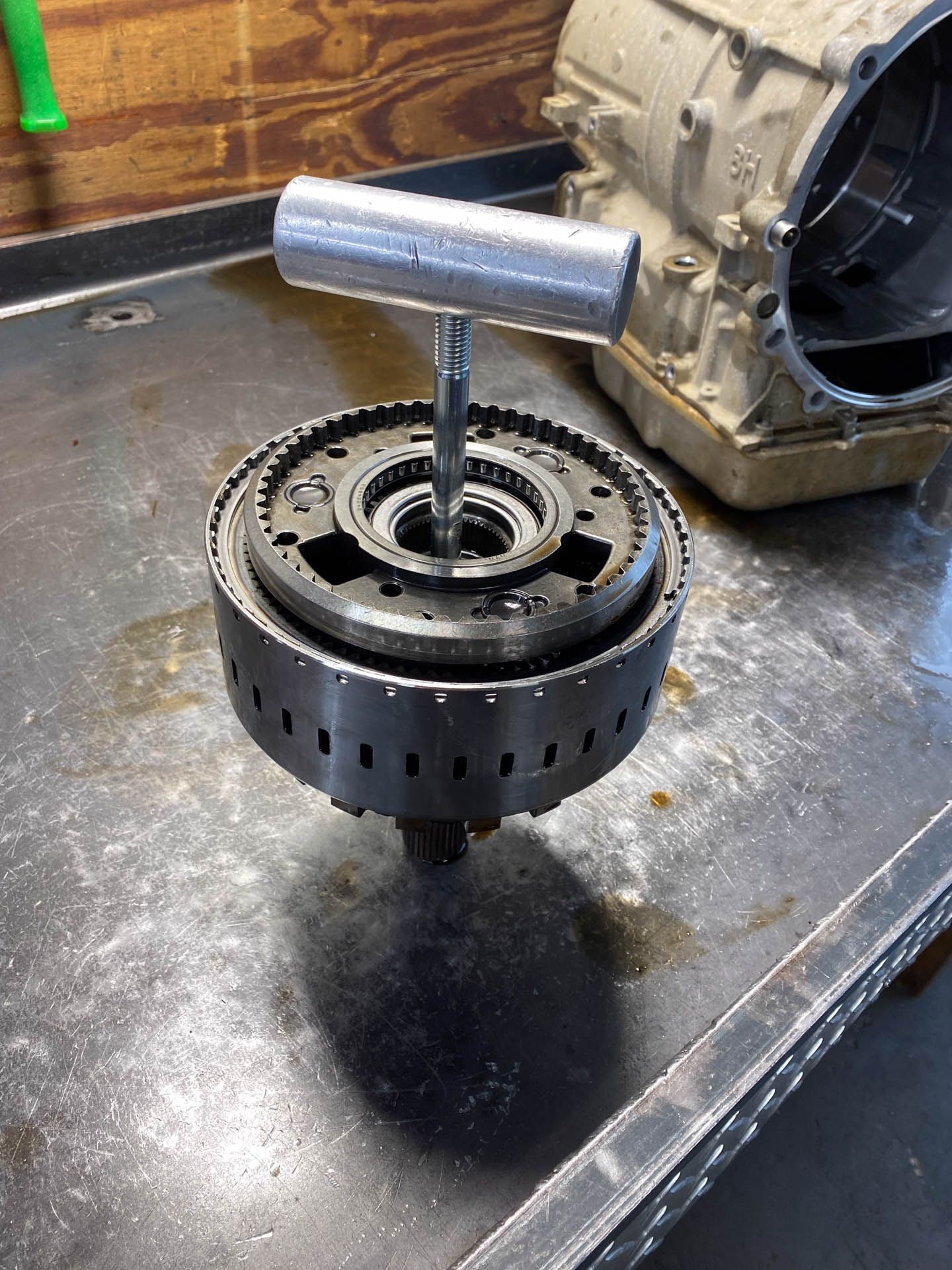 A metal object with a handle is sitting on a metal surface.