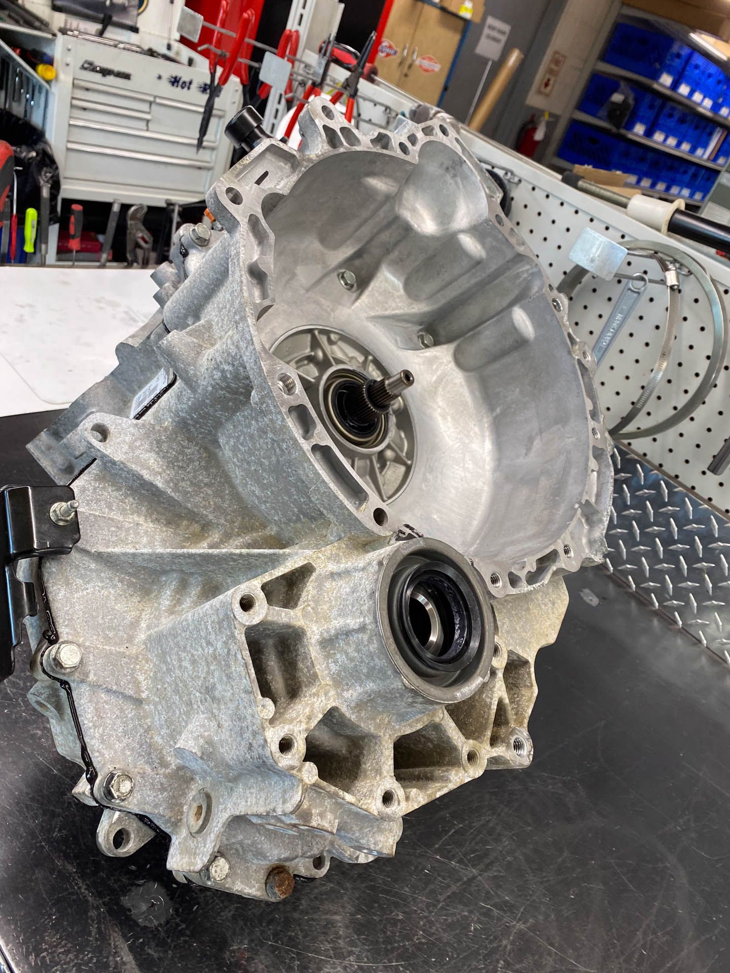 A car engine is sitting on a table in a garage.