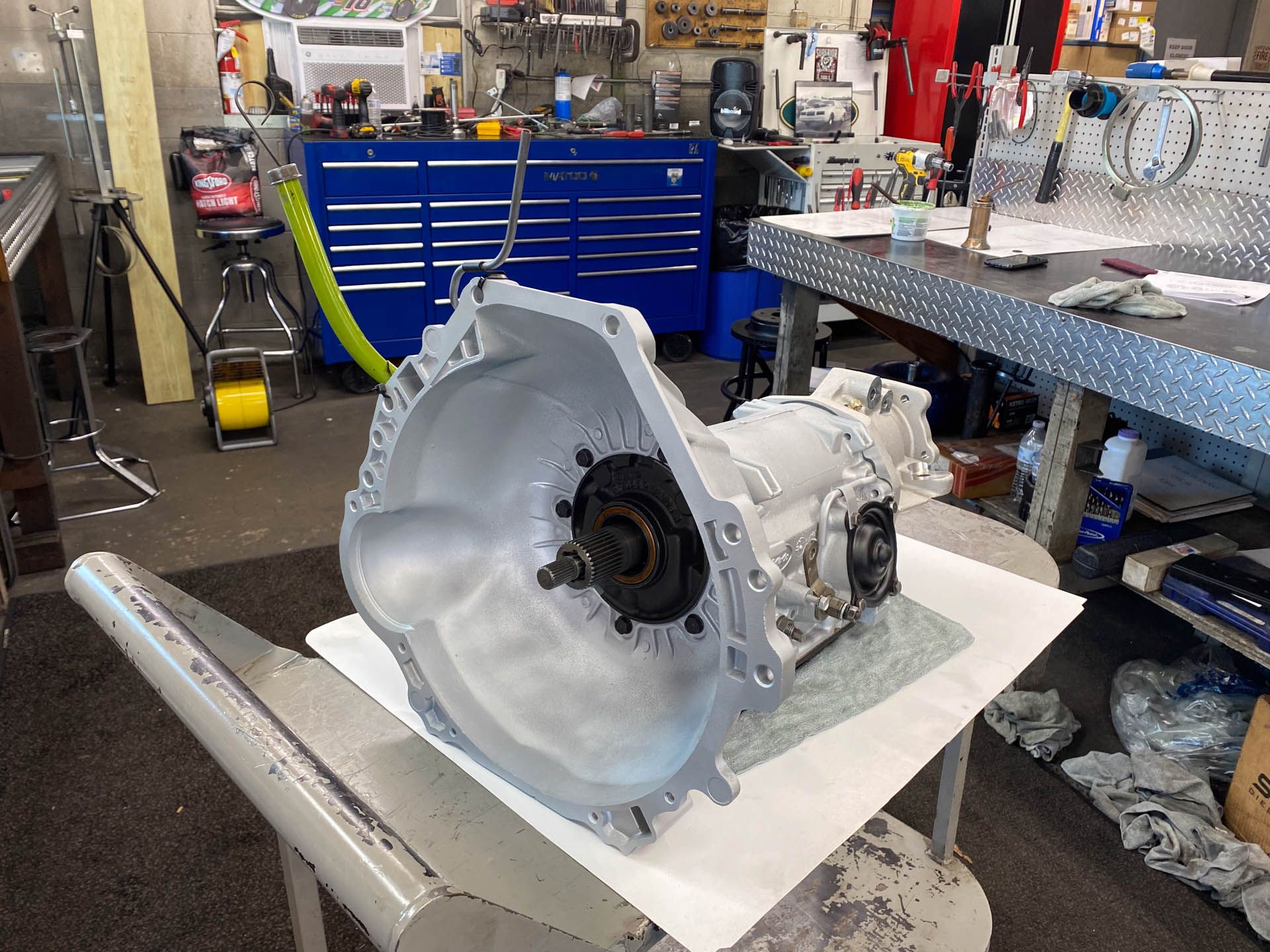 A gearbox is sitting on a table in a garage.