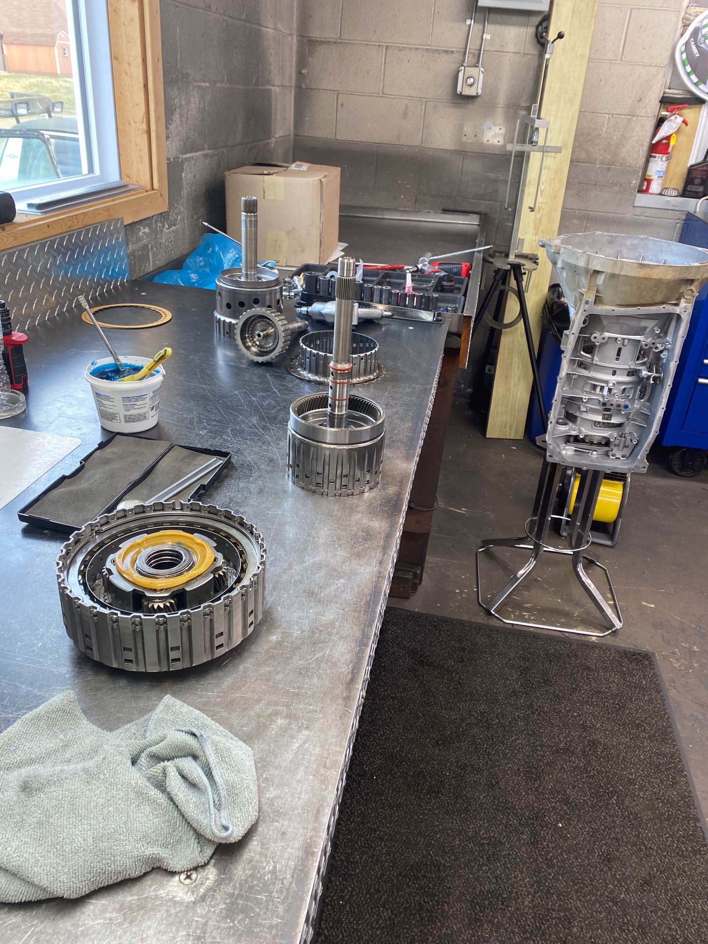 A table with a bunch of gears on it in a garage.