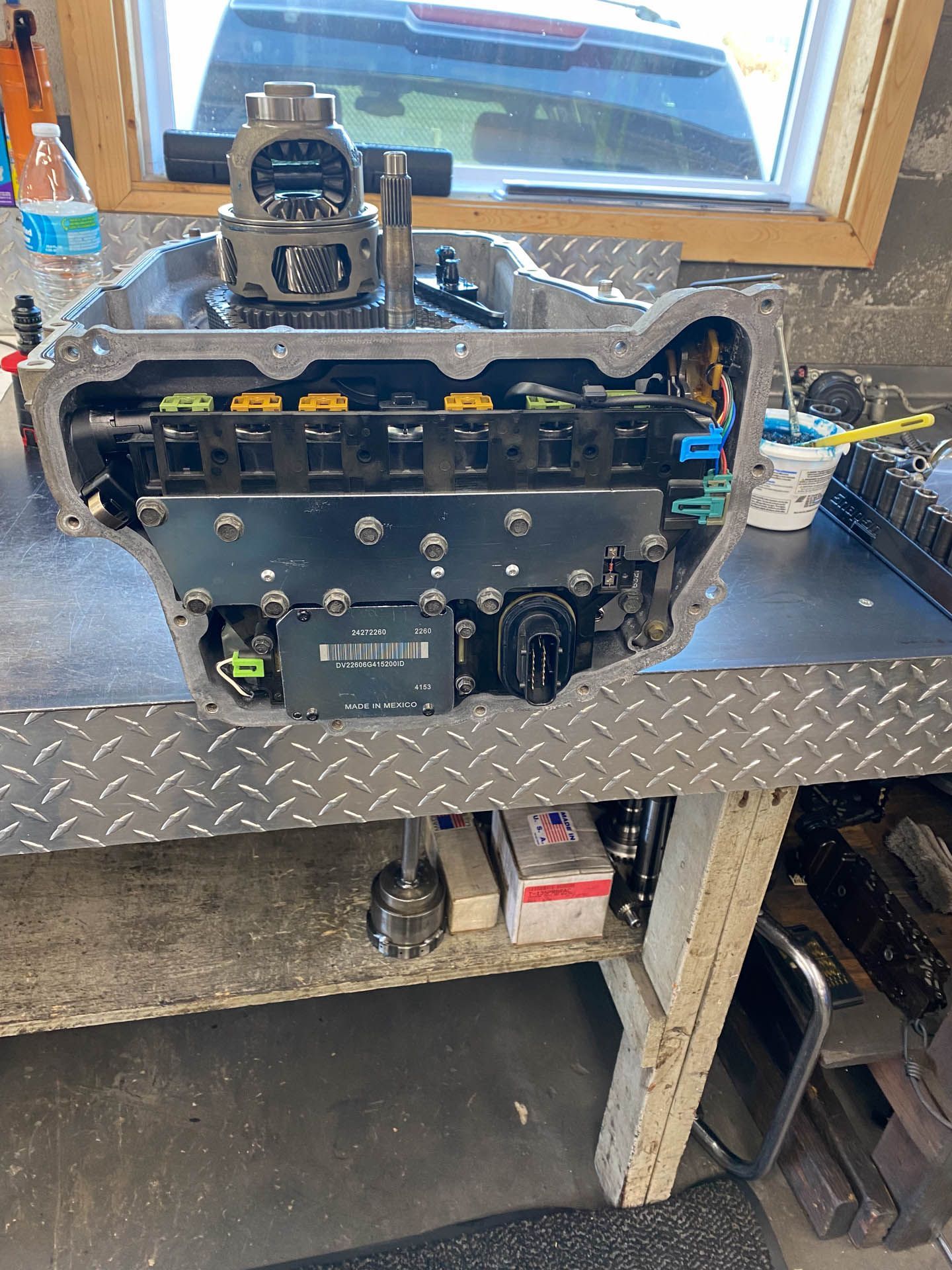 A car engine is sitting on top of a metal table.