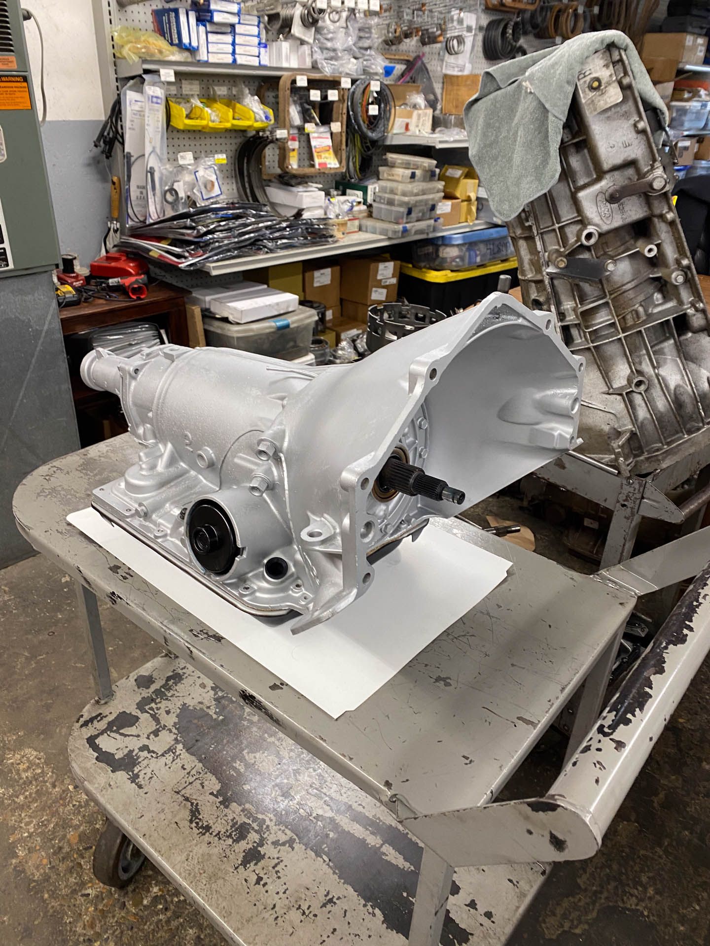 A gearbox is sitting on top of a cart in a garage.