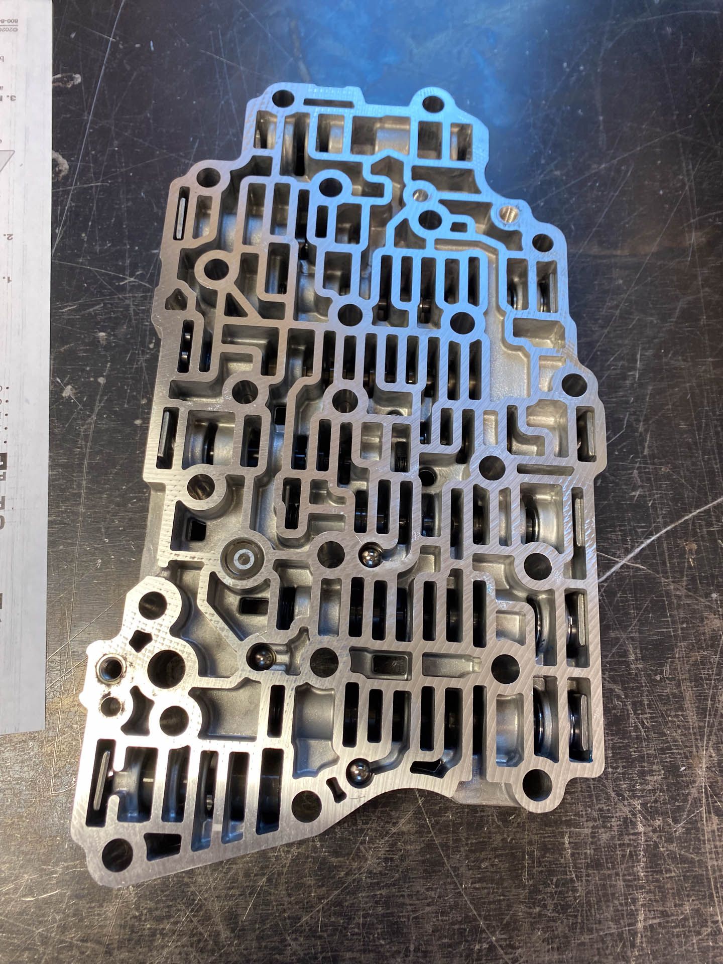 A piece of metal is sitting on a table next to a ruler.