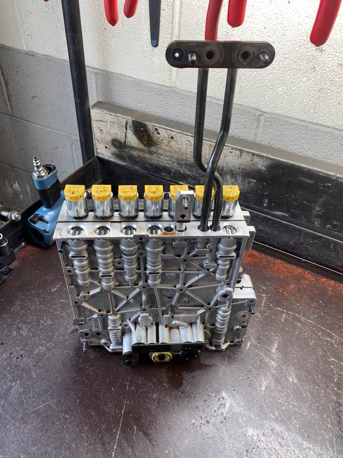 A mechanical device is sitting on a table next to tools.