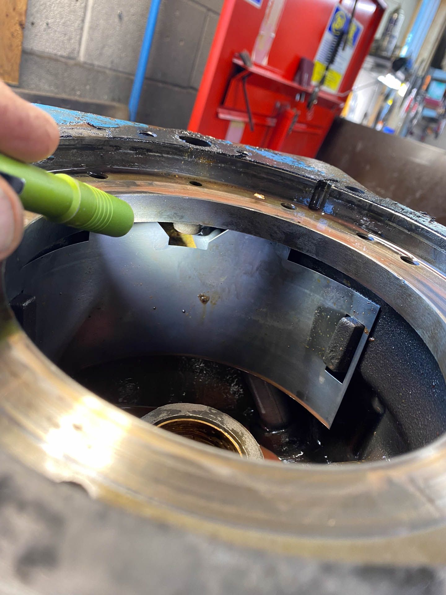 A person is holding a green pen in a hole in a machine.