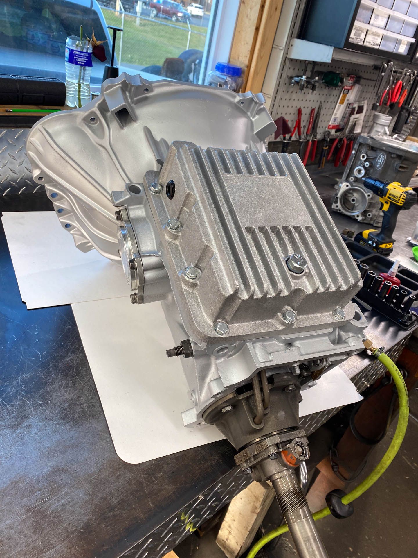 A transmission is sitting on top of a table in a garage.