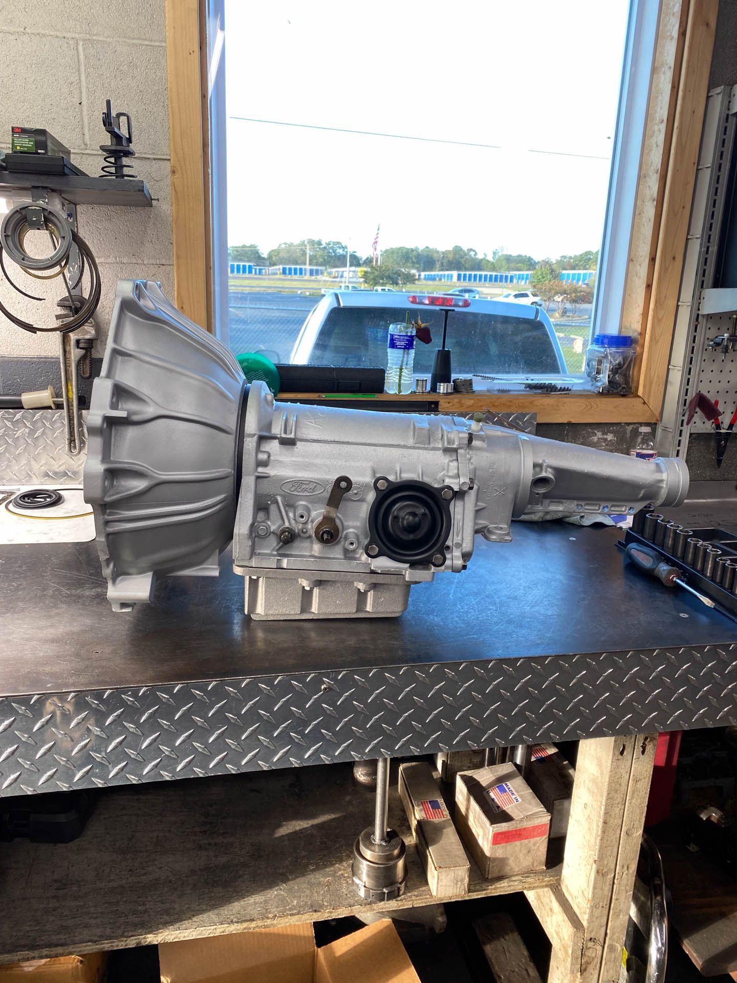 A gearbox is sitting on a metal table in front of a window.