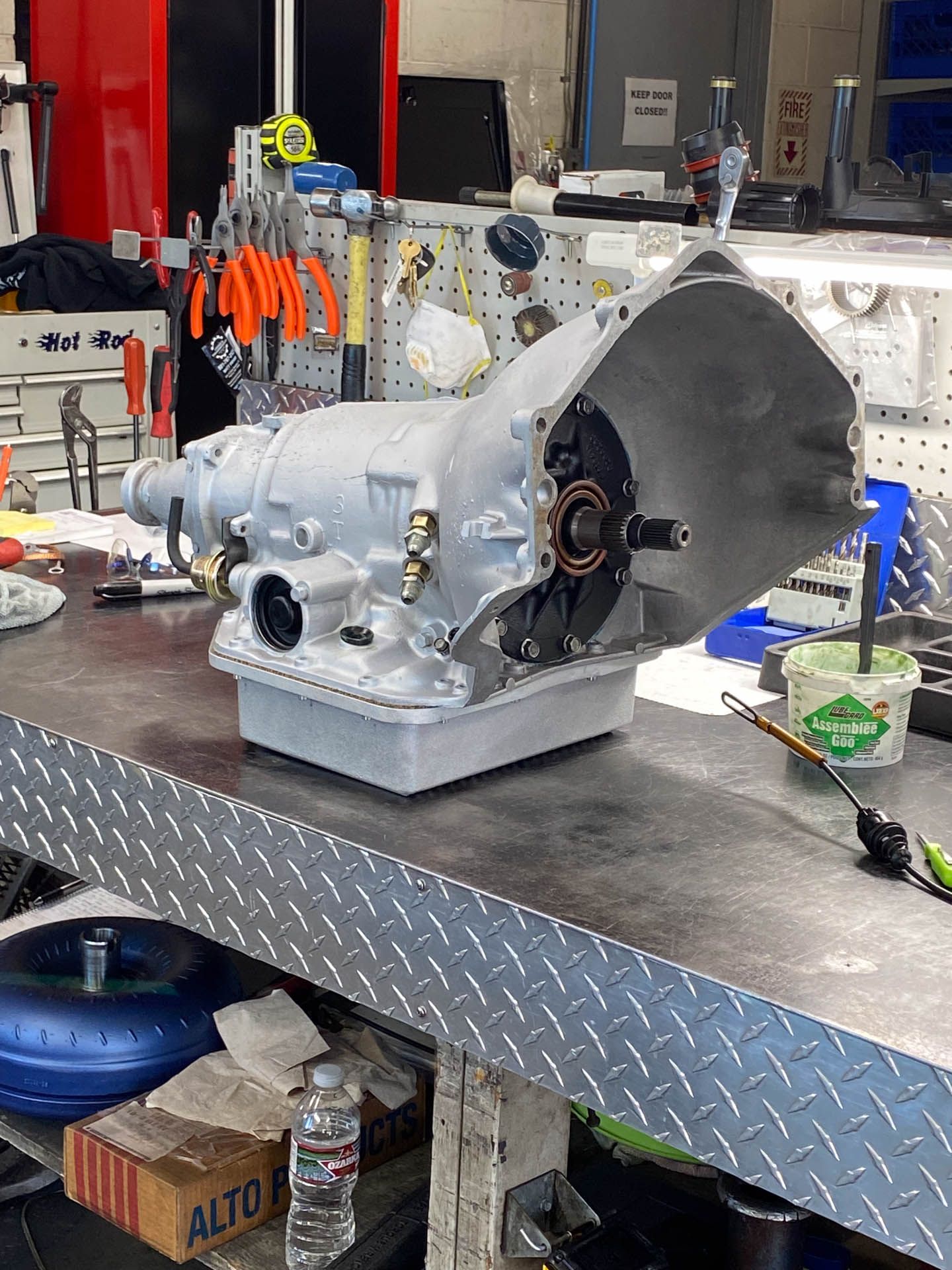 A gearbox is sitting on a metal table in a garage.
