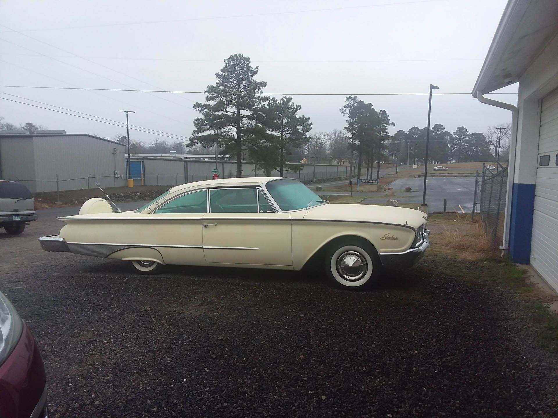 A white car is parked in front of a garage