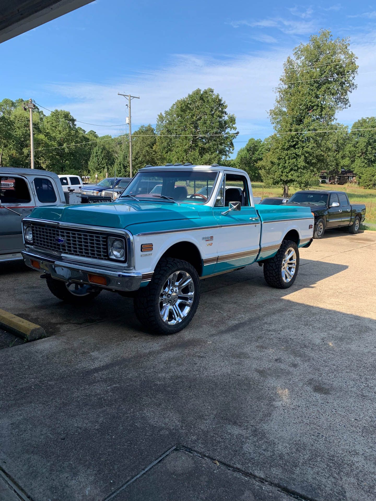 A blue and white truck is parked in a parking lot.