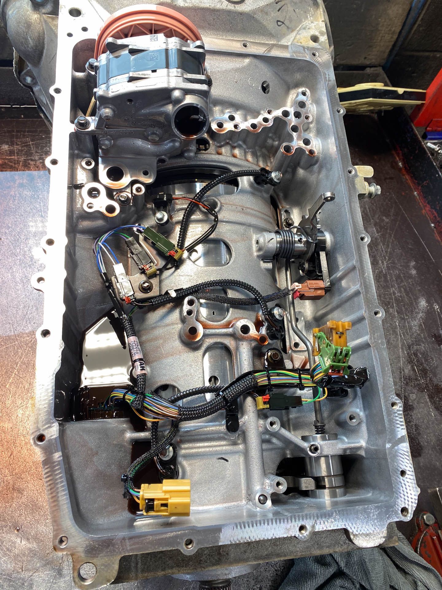 The inside of a car engine with a lot of wires coming out of it.