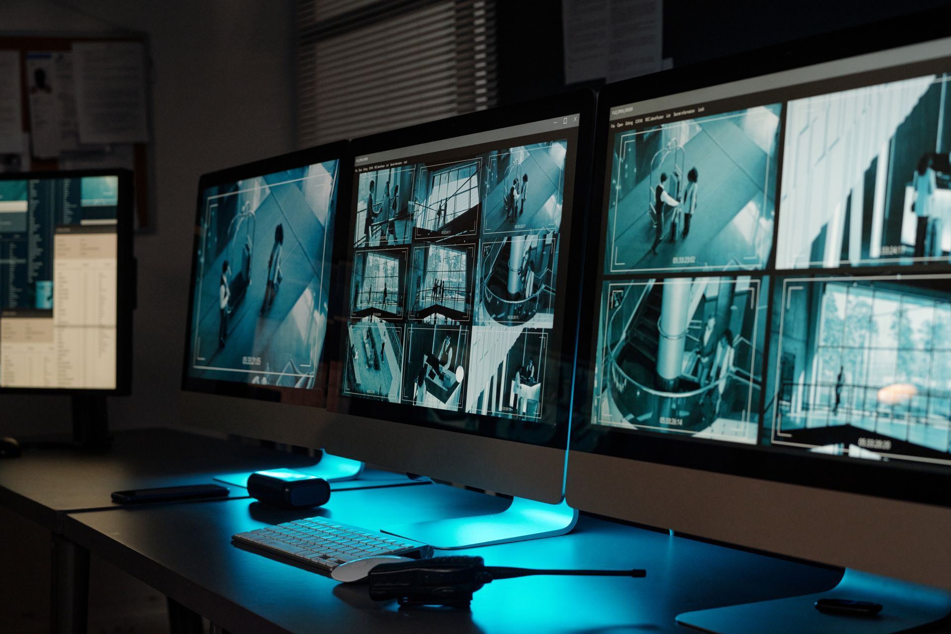 A row of computer monitors are sitting on a desk.