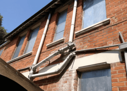 A brick building with a lot of pipes attached to it