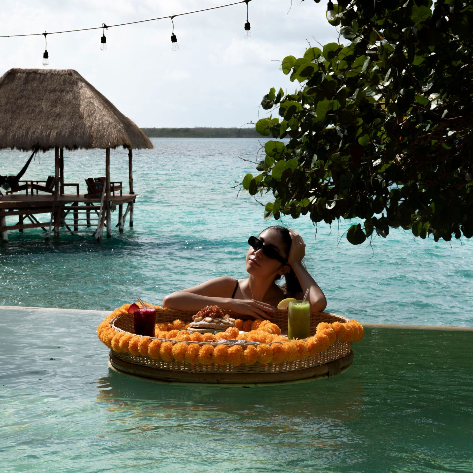 Una mujer está acostada en una balsa en el océano.