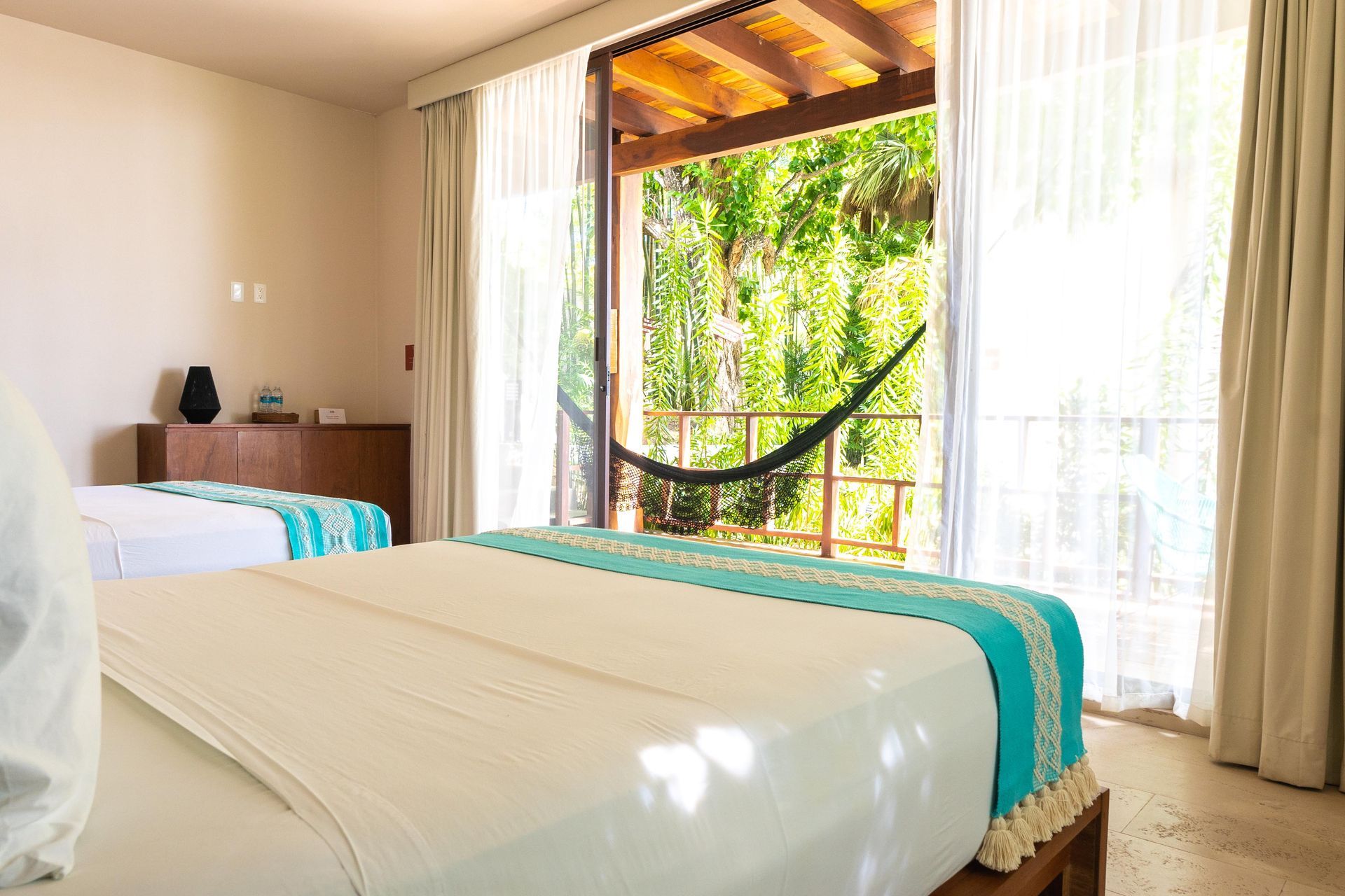 Una habitación de hotel con dos camas y una hamaca.
