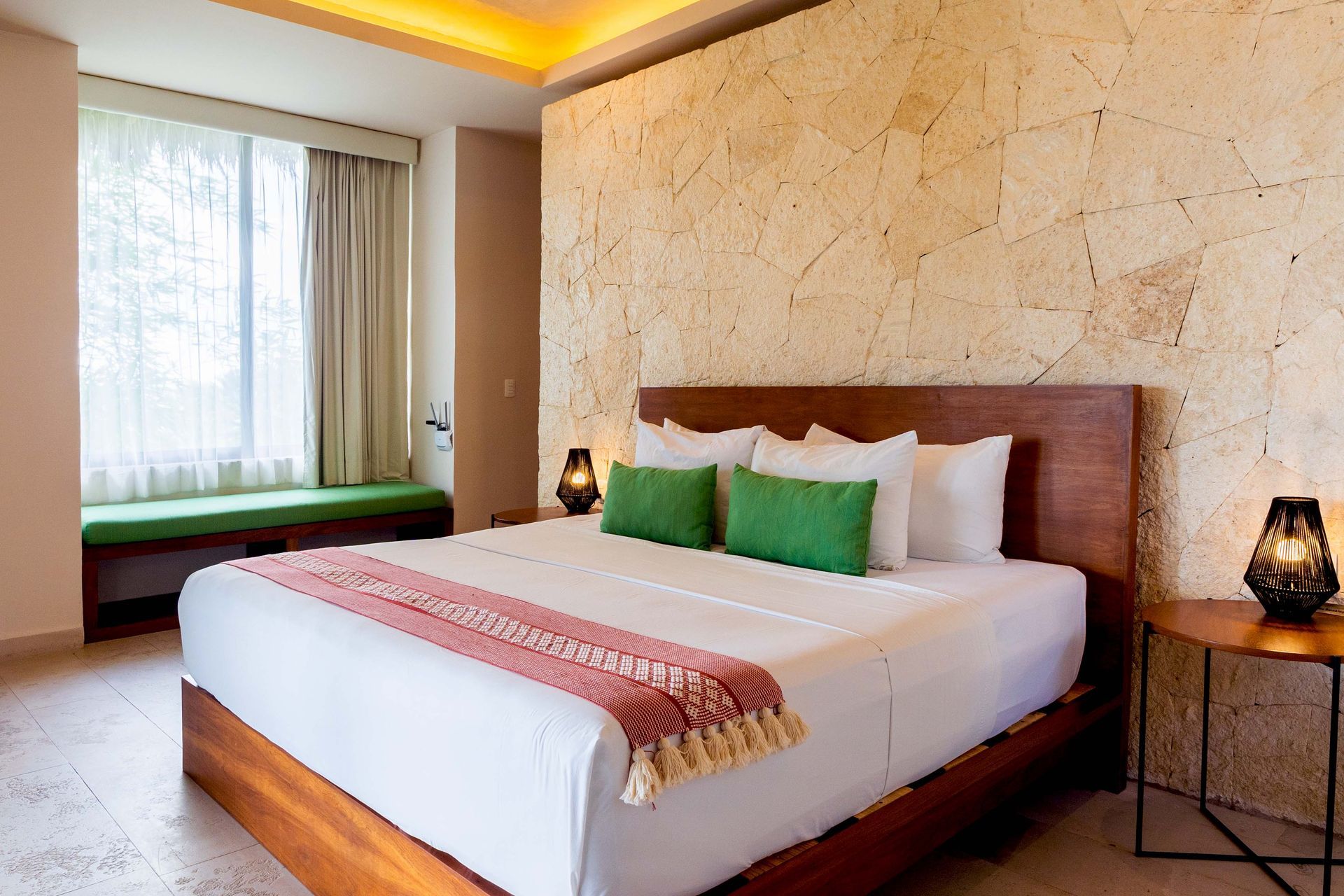 Una habitación de hotel con una cama king size y una pared de piedra.