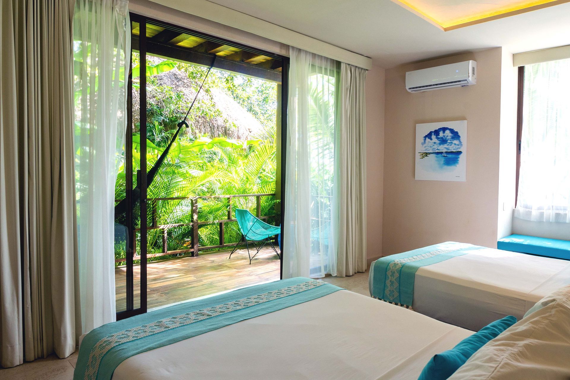 Una habitación de hotel con dos camas y una puerta corrediza de vidrio que conduce a un balcón.
