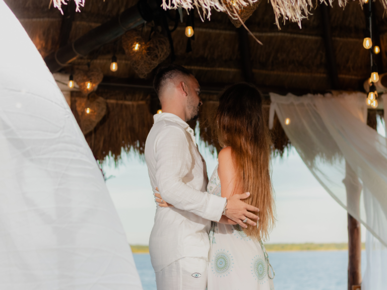 Un hombre y una mujer bailan bajo un techo de paja.