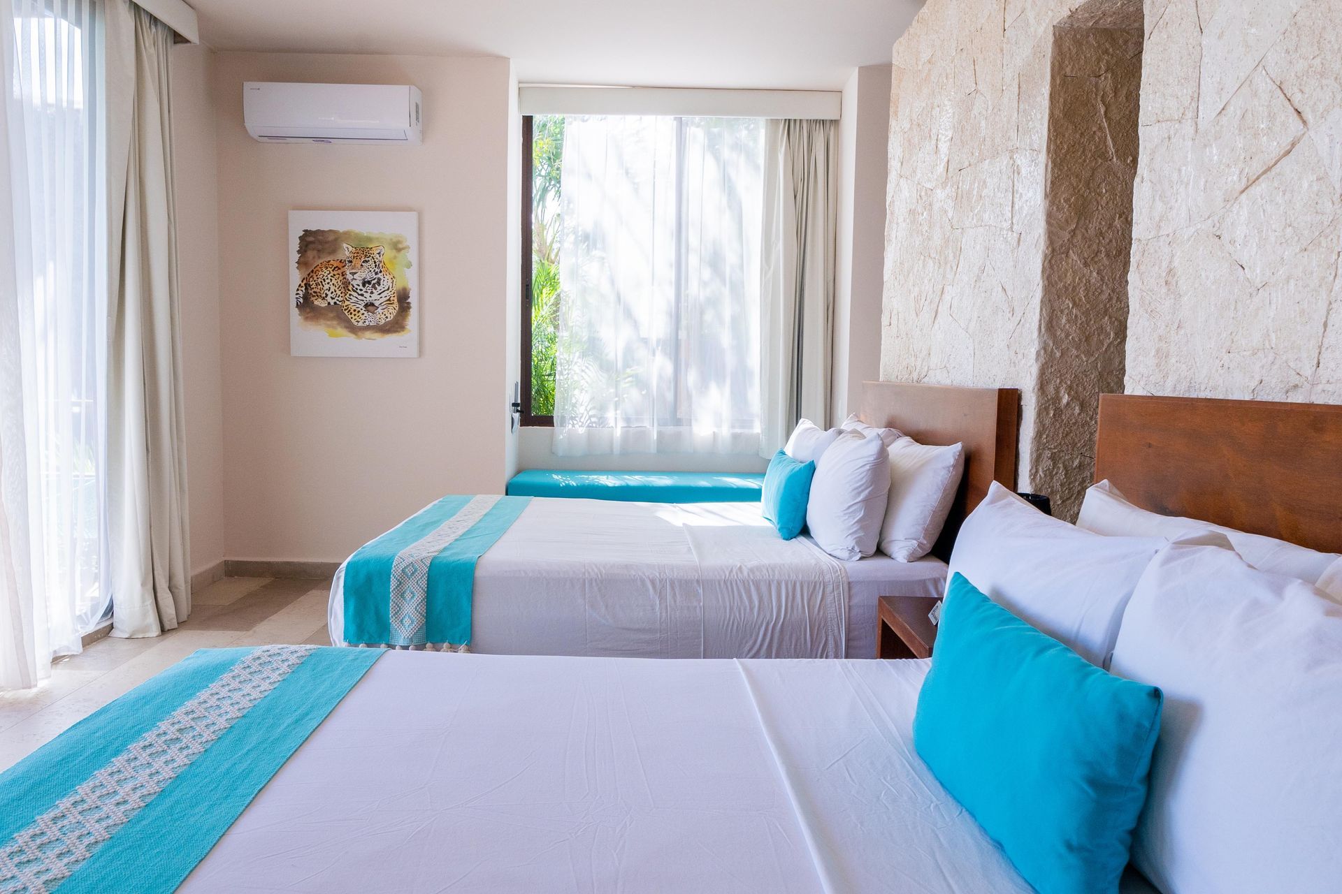 Una habitación de hotel con dos camas y una ventana grande.