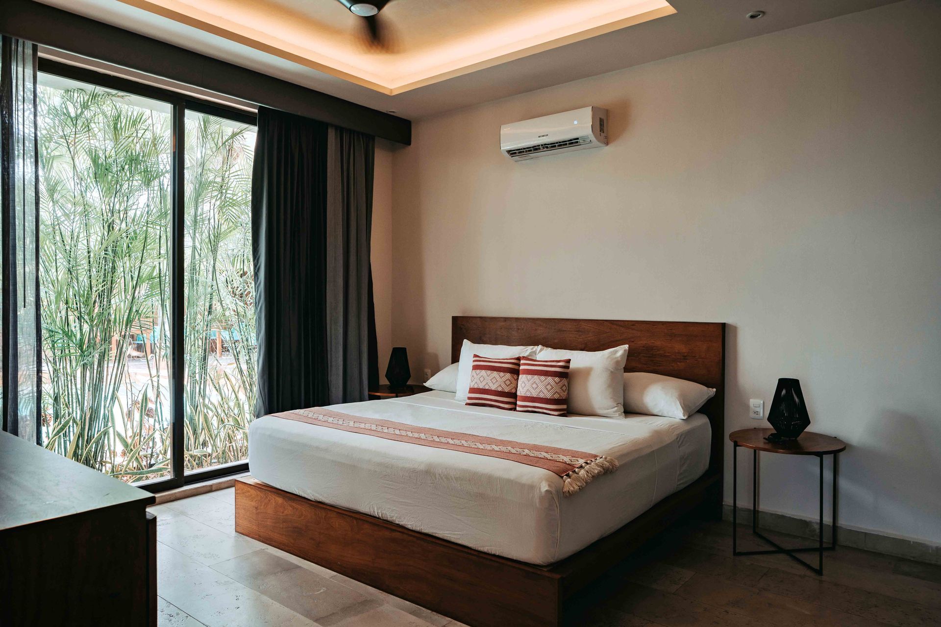 Un dormitorio con una cama grande, puertas corredizas de vidrio y un ventilador de techo.