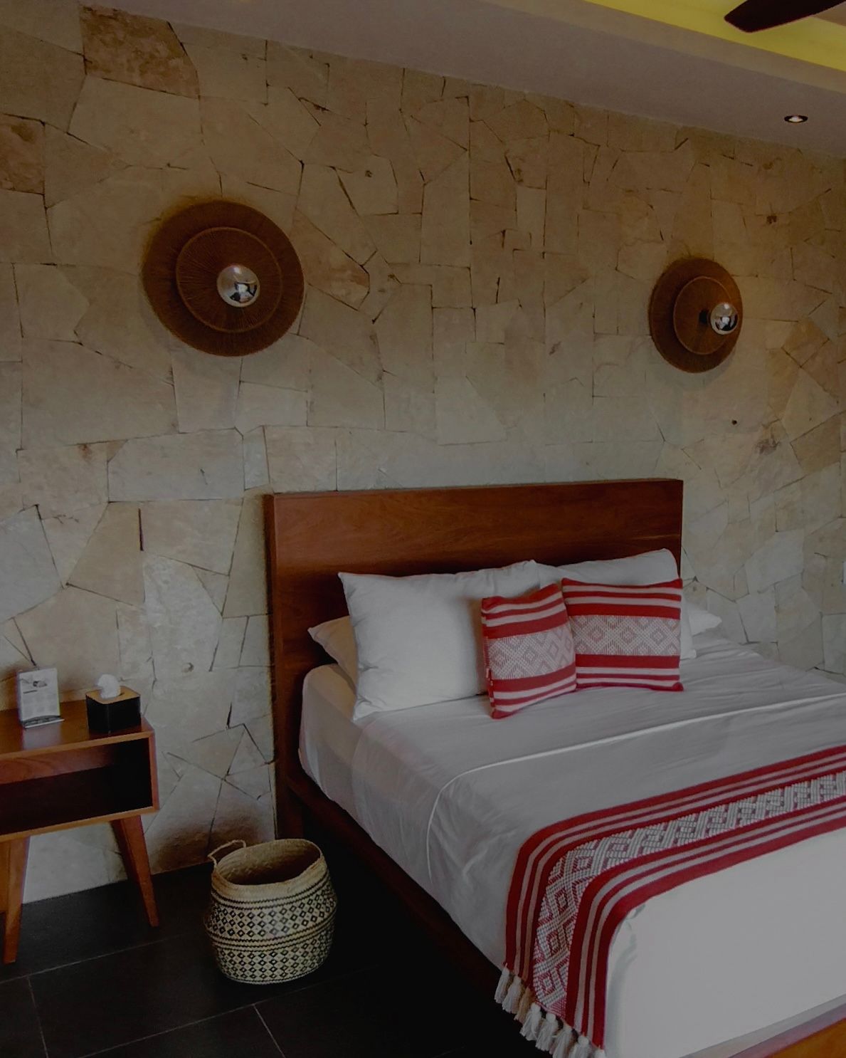 Un dormitorio con una cama y dos lámparas en la pared.