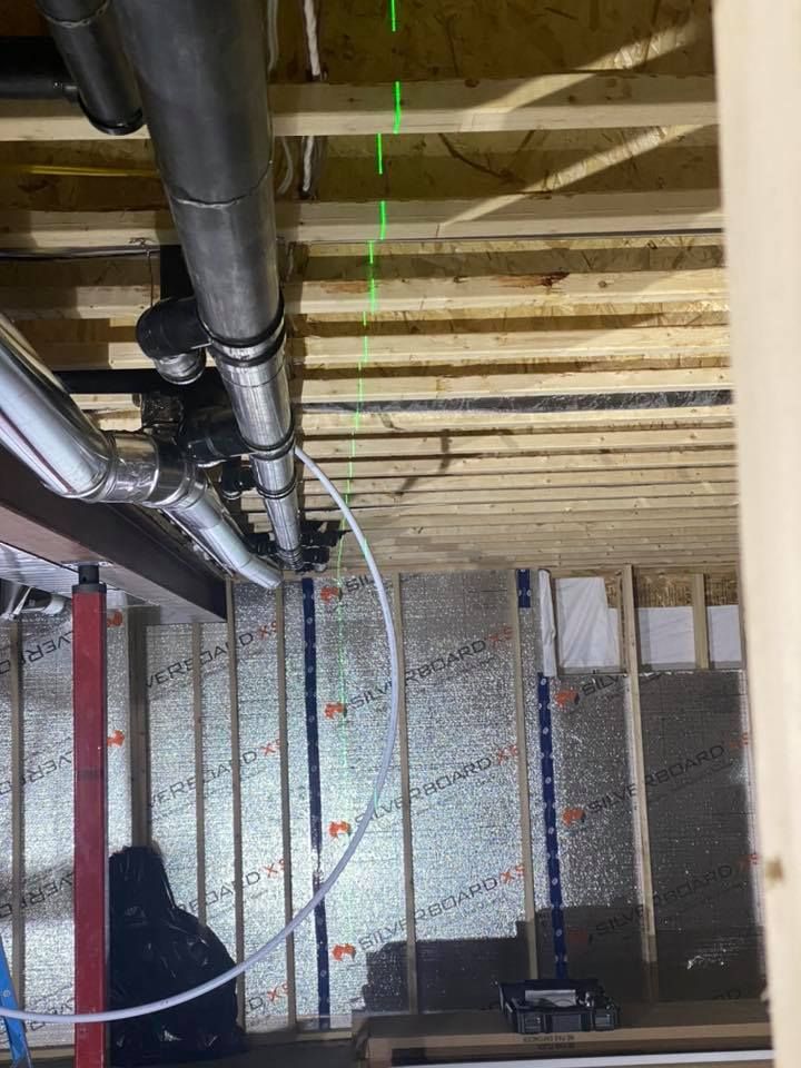 A green laser is being used to measure the ceiling of a building under construction.