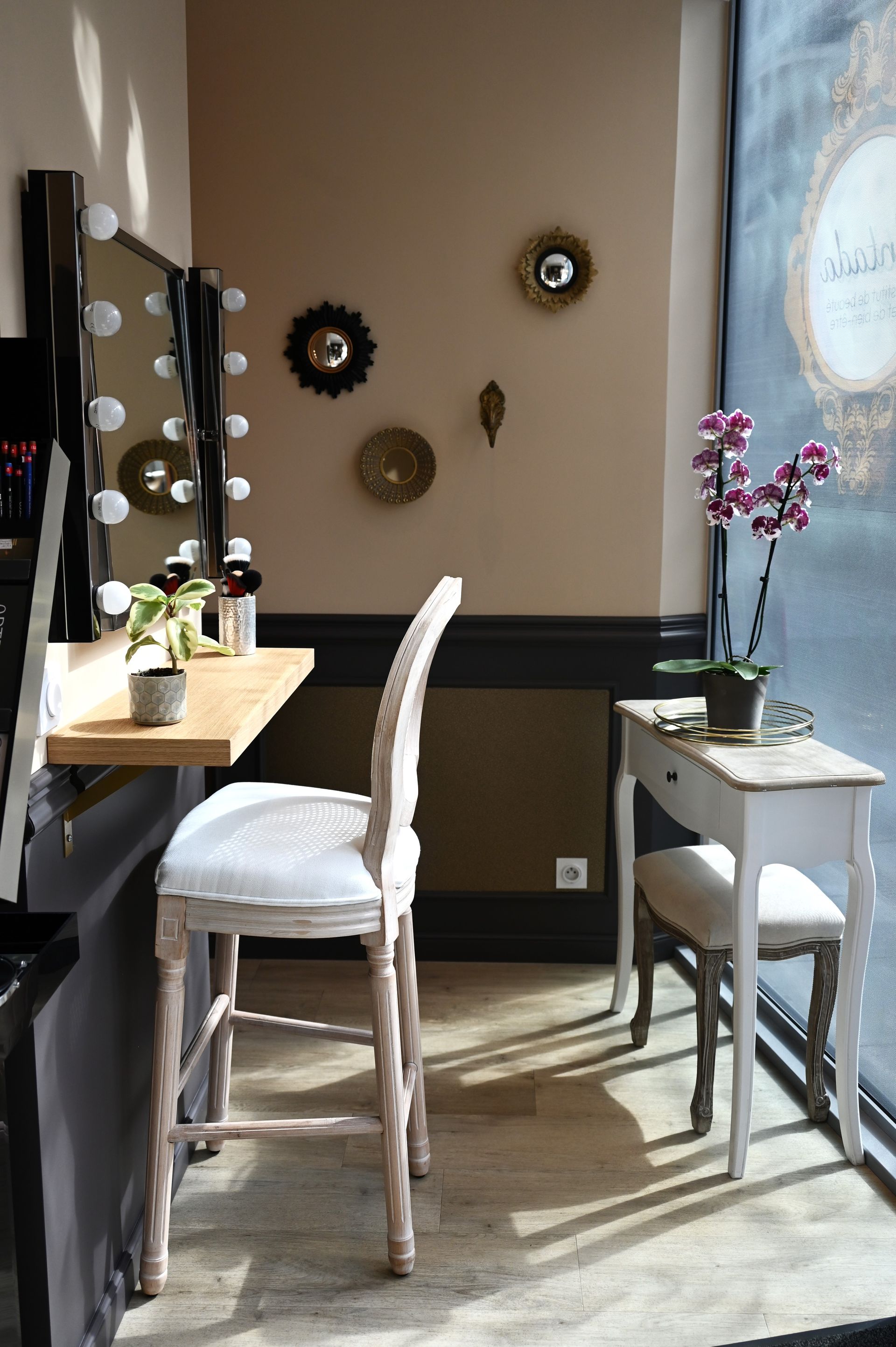 Une pièce avec une table, des chaises, des miroirs et une fenêtre.