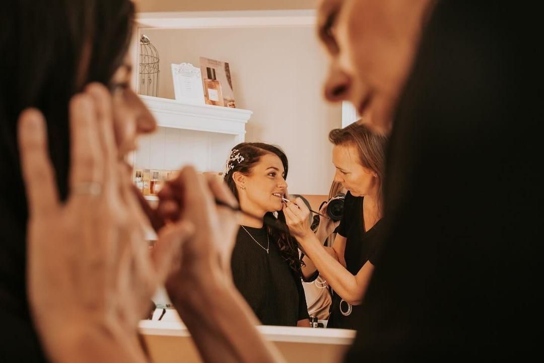 Une femme applique du mascara sur ses yeux.