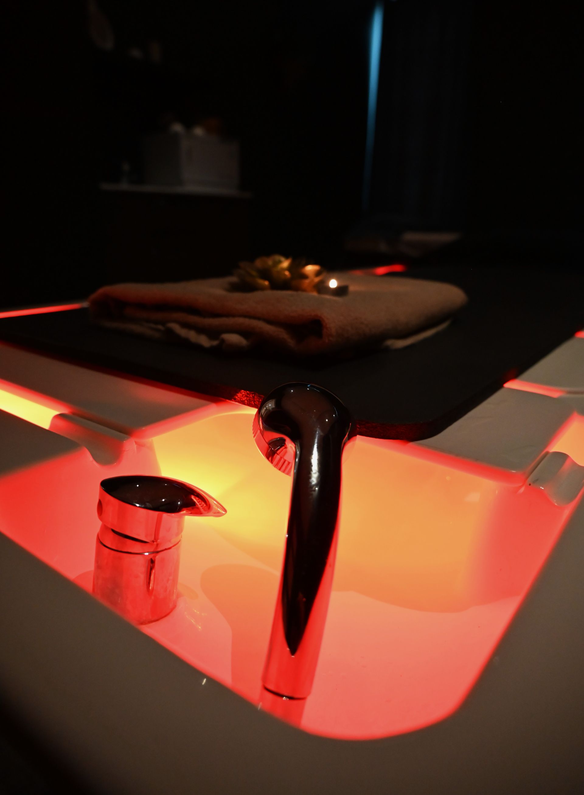 Une chambre avec deux lits de massage et une télévision au mur.