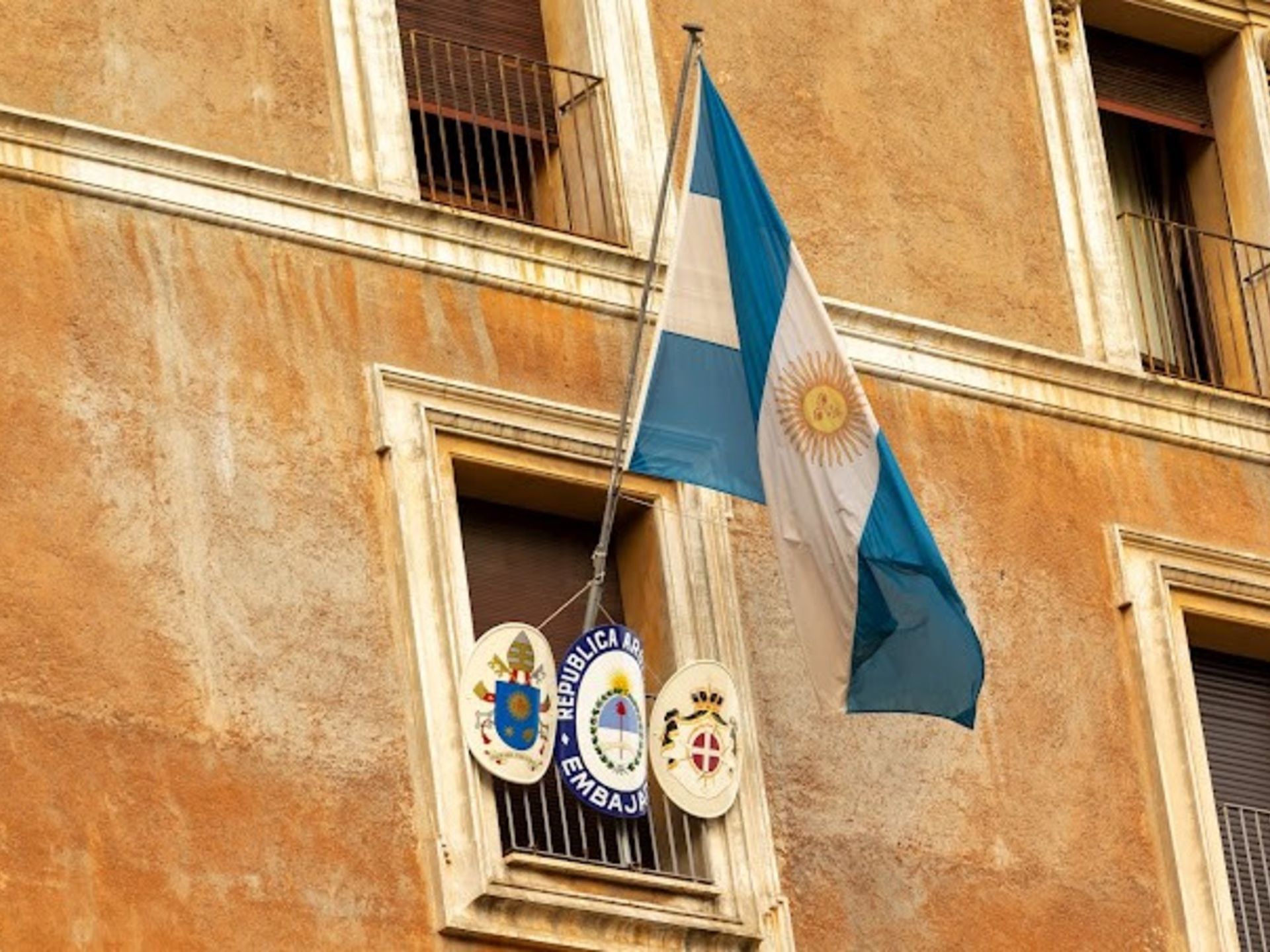 La bandera de Argentina ondea frente a un edificio.