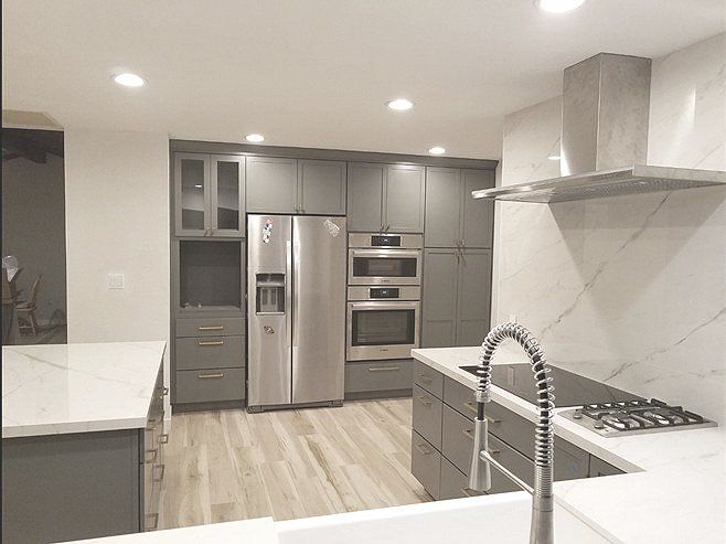 A kitchen with stainless steel appliances and gray cabinets