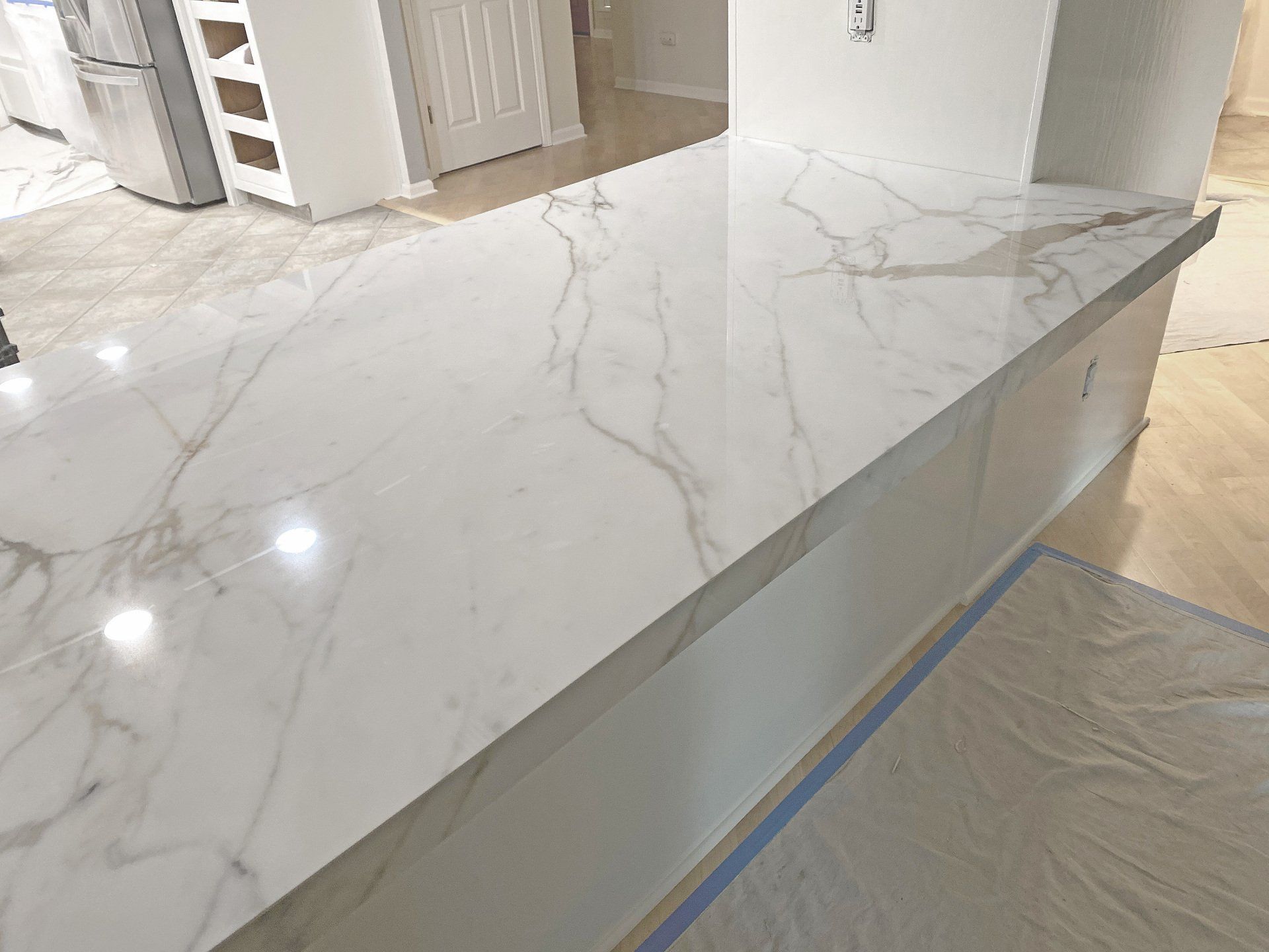 A kitchen counter with a white marble counter top.