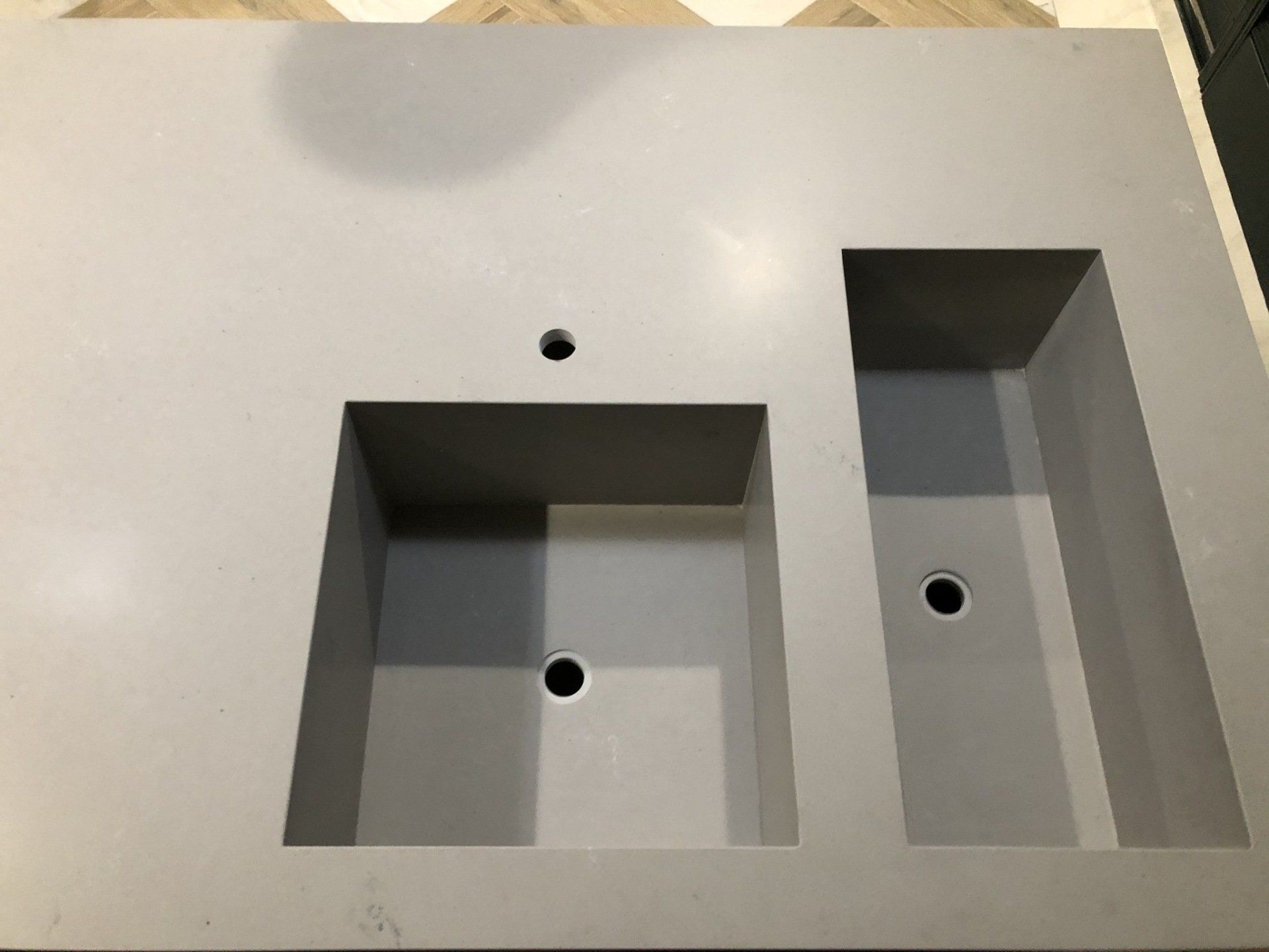 A sink with two holes in it is sitting on a counter.