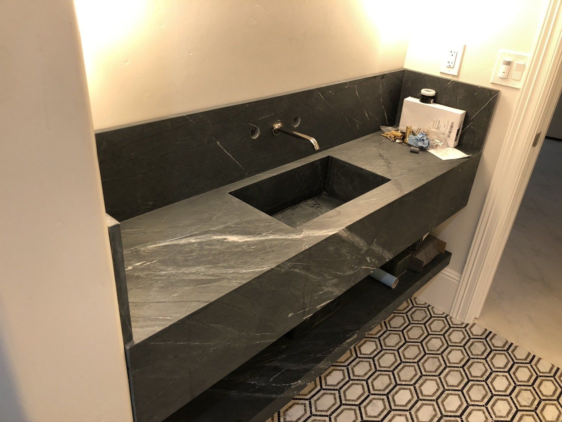 A bathroom with a sink and a marble counter top.