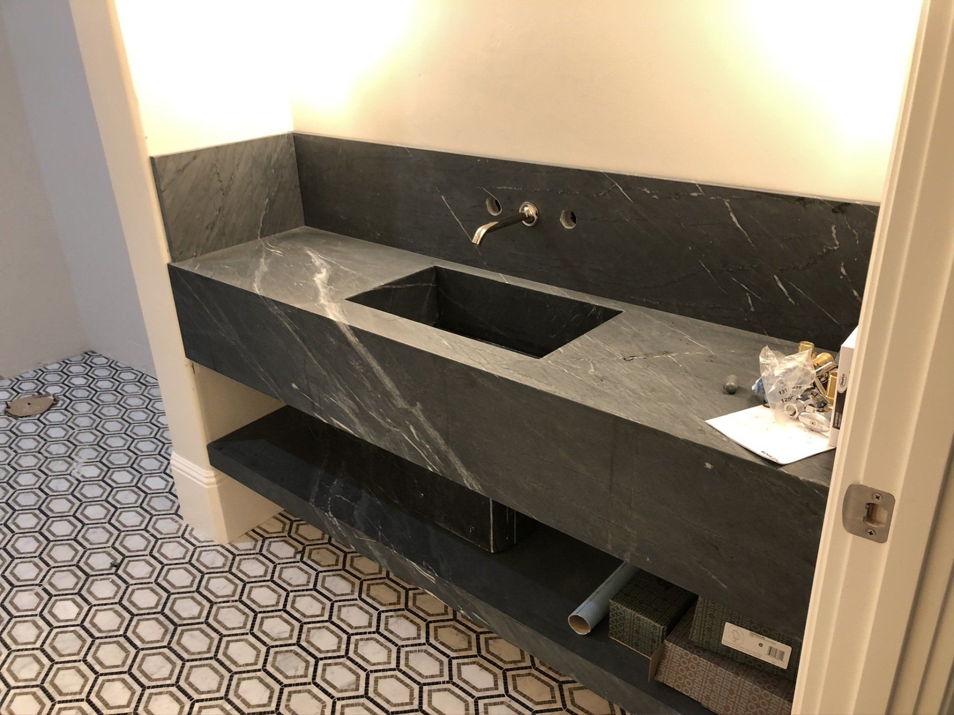 A bathroom with a black sink and a black and white tile floor.