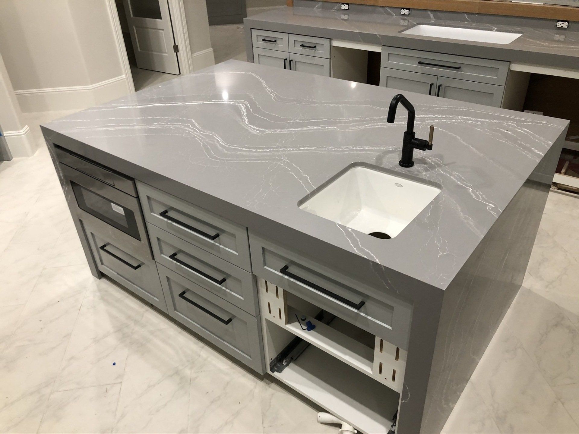 A kitchen with a large island and a sink.