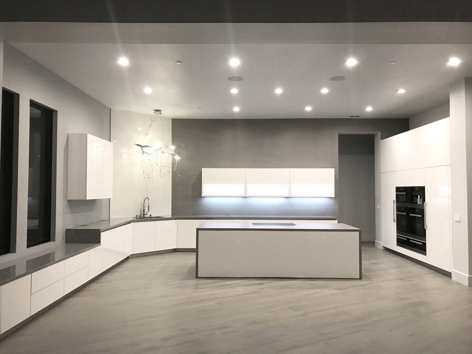 A kitchen with white cabinets and a large island in the middle.