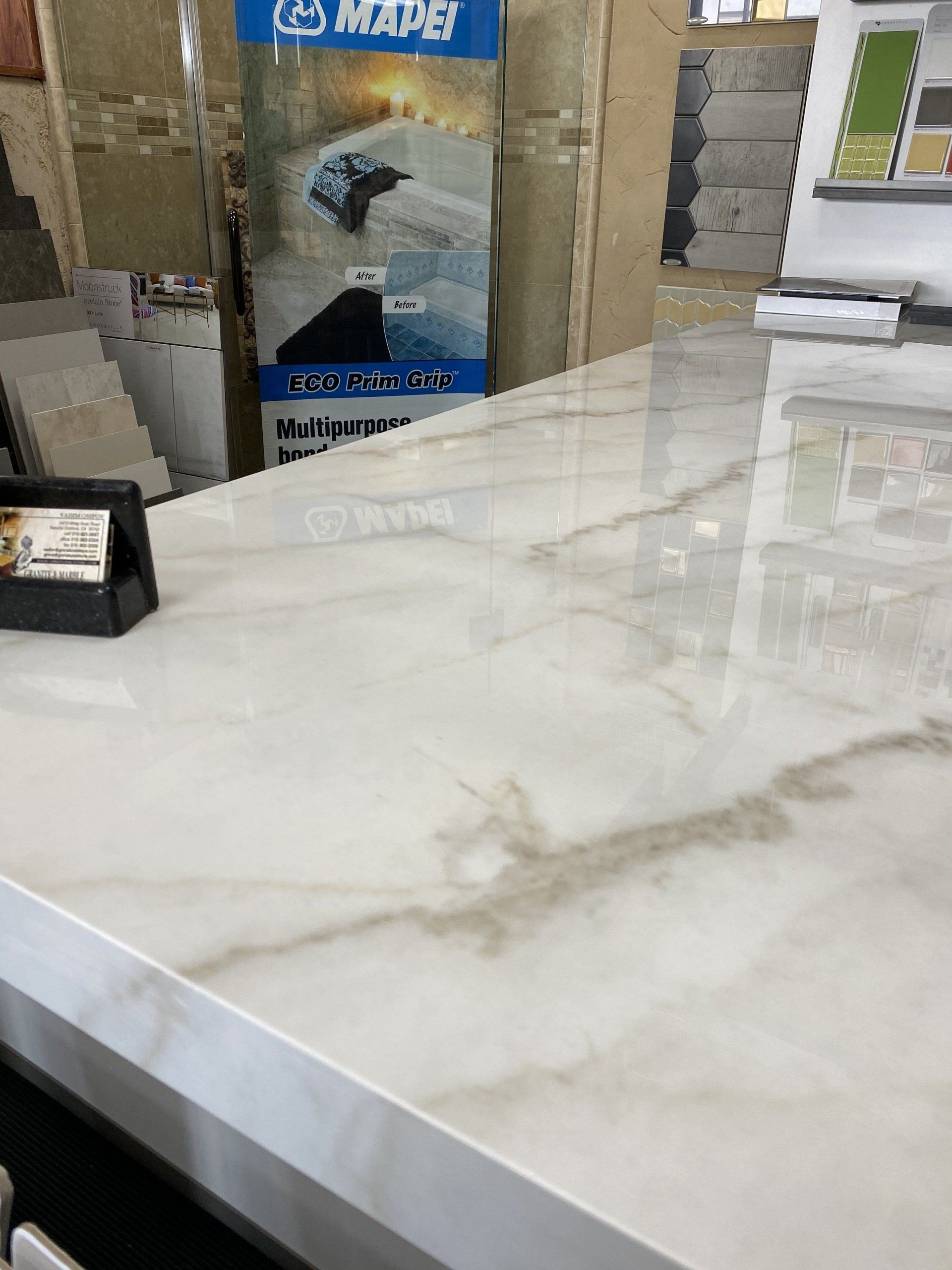 A white marble counter top with a sign in the background that says mape