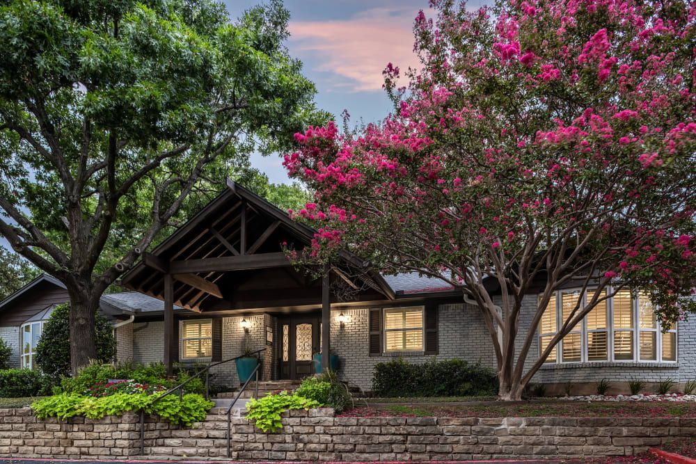 a house with pink flowers and trees in front of it at The Park at Flower Mound in Flower Mound, TX.