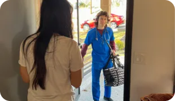 A nurse is talking to a woman in a doorway.