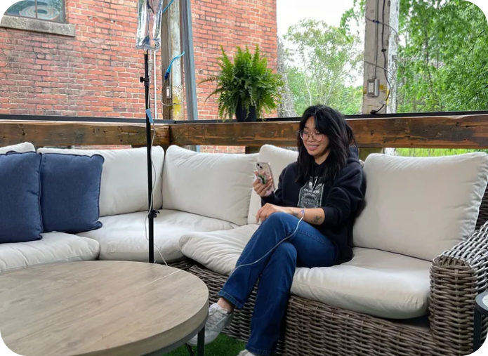 A woman is sitting on a couch looking at her phone.