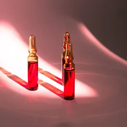 Two bottles of red liquid are sitting on a table