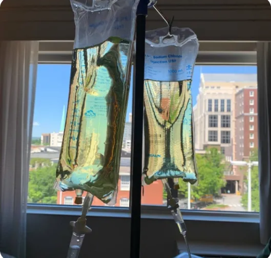 A bag of liquid is hanging from the ceiling in a living room