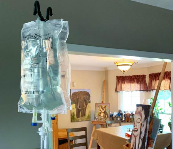 A bag of liquid is hanging from a hook in a room