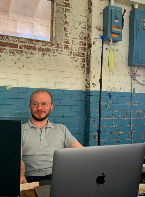 A man is sitting in front of an apple laptop