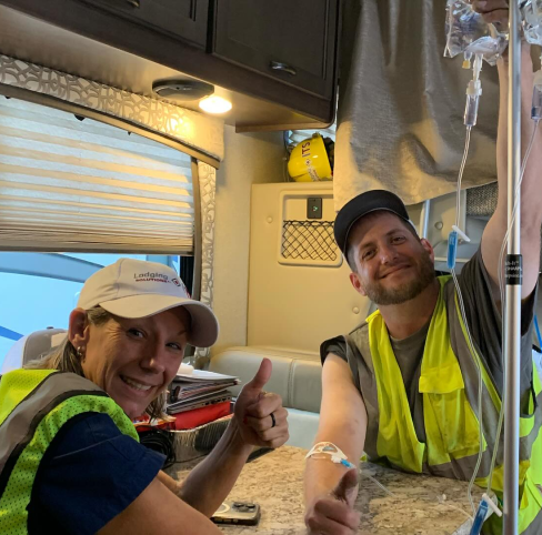 A man and a woman are giving a thumbs up in a rv.