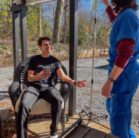 A man sitting in a chair talking to a nurse