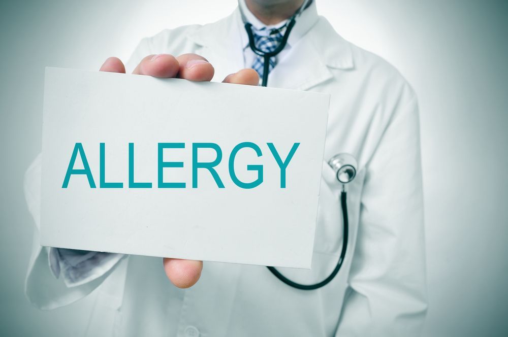 A doctor is holding a sign that says allergy