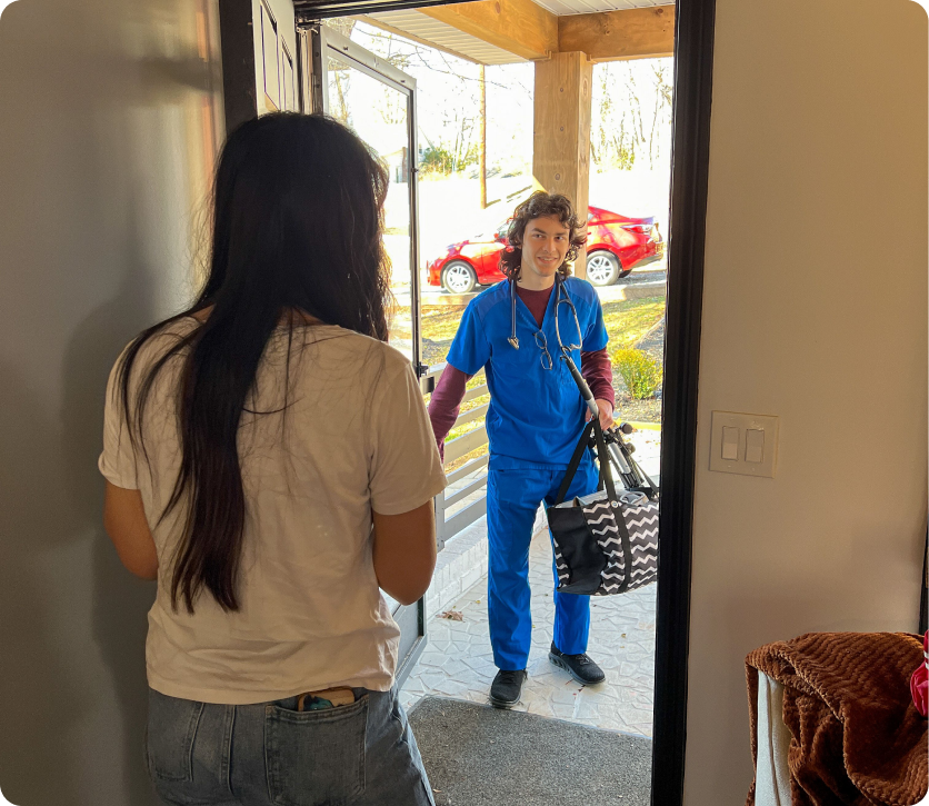 A nurse is talking to a woman in a doorway.