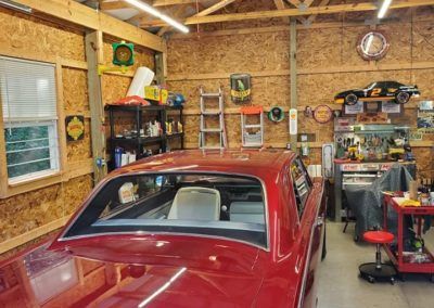 A red car is parked in a garage.